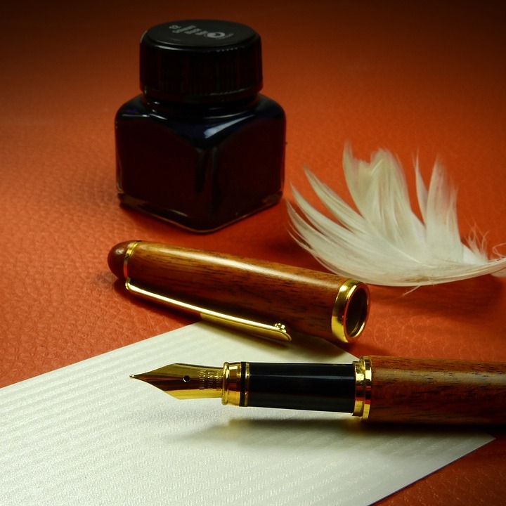 quill pen, inkwell, and paper