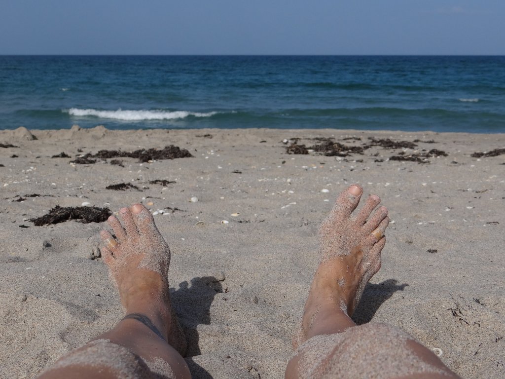 My feet in the sand with the ocean in the background