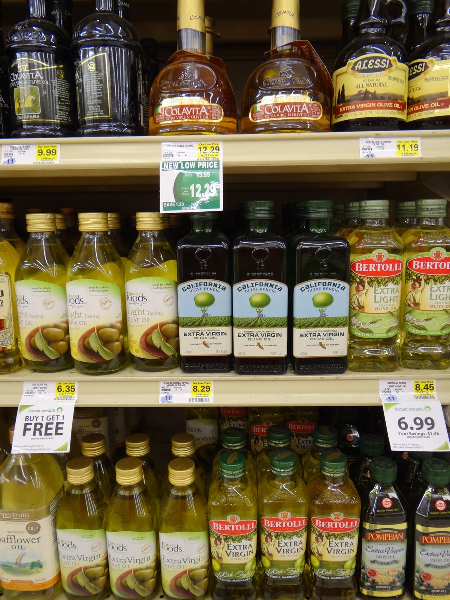 grocery store shelves filled with olive oil bottles