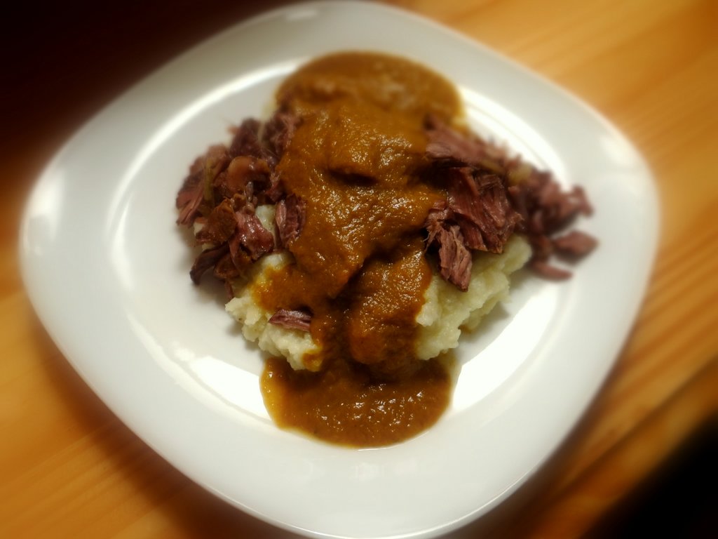 plate with pot roast, mashed cauliflower, and delicious gravy poured on top