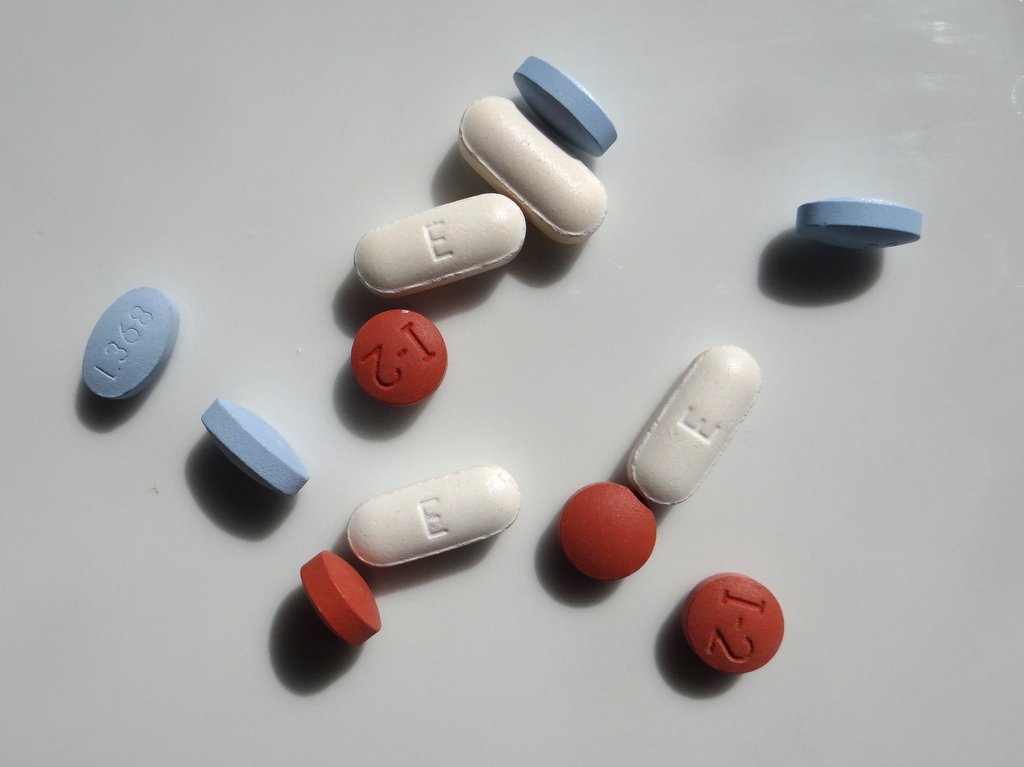 a variety of NSAID pills scattered on a white background