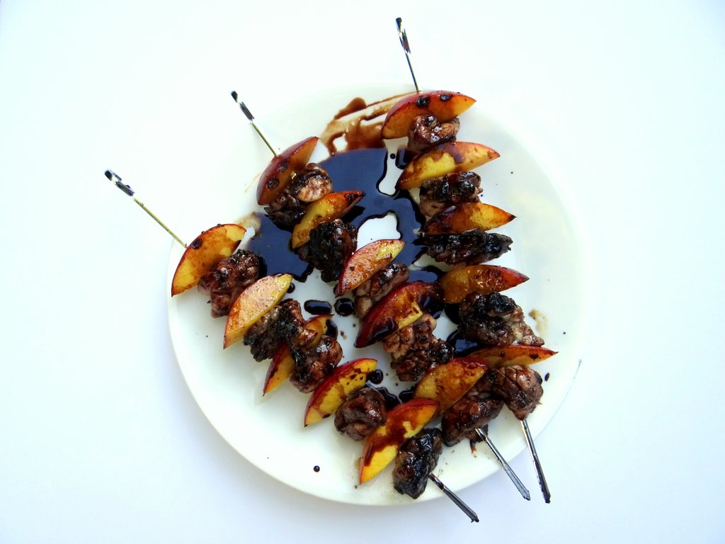 The cooked sweetbread skewers on a plate, drizzled with glaze