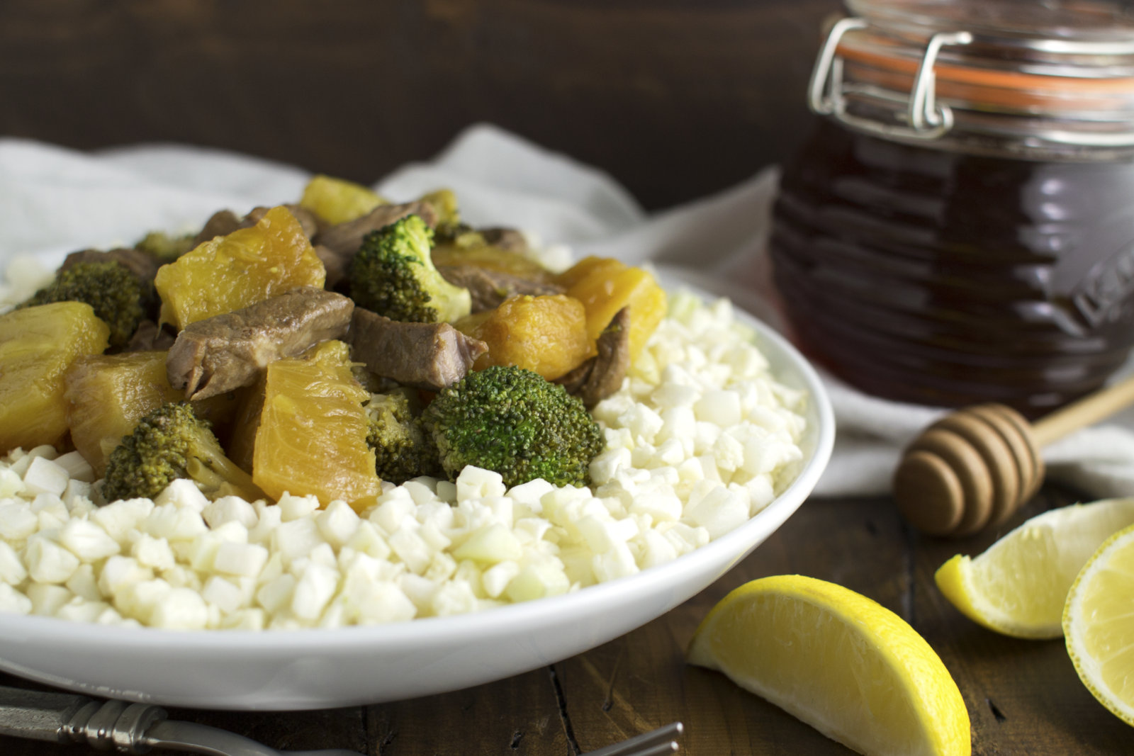 photo of stir fry on a plate with a cute jar of honey in the background