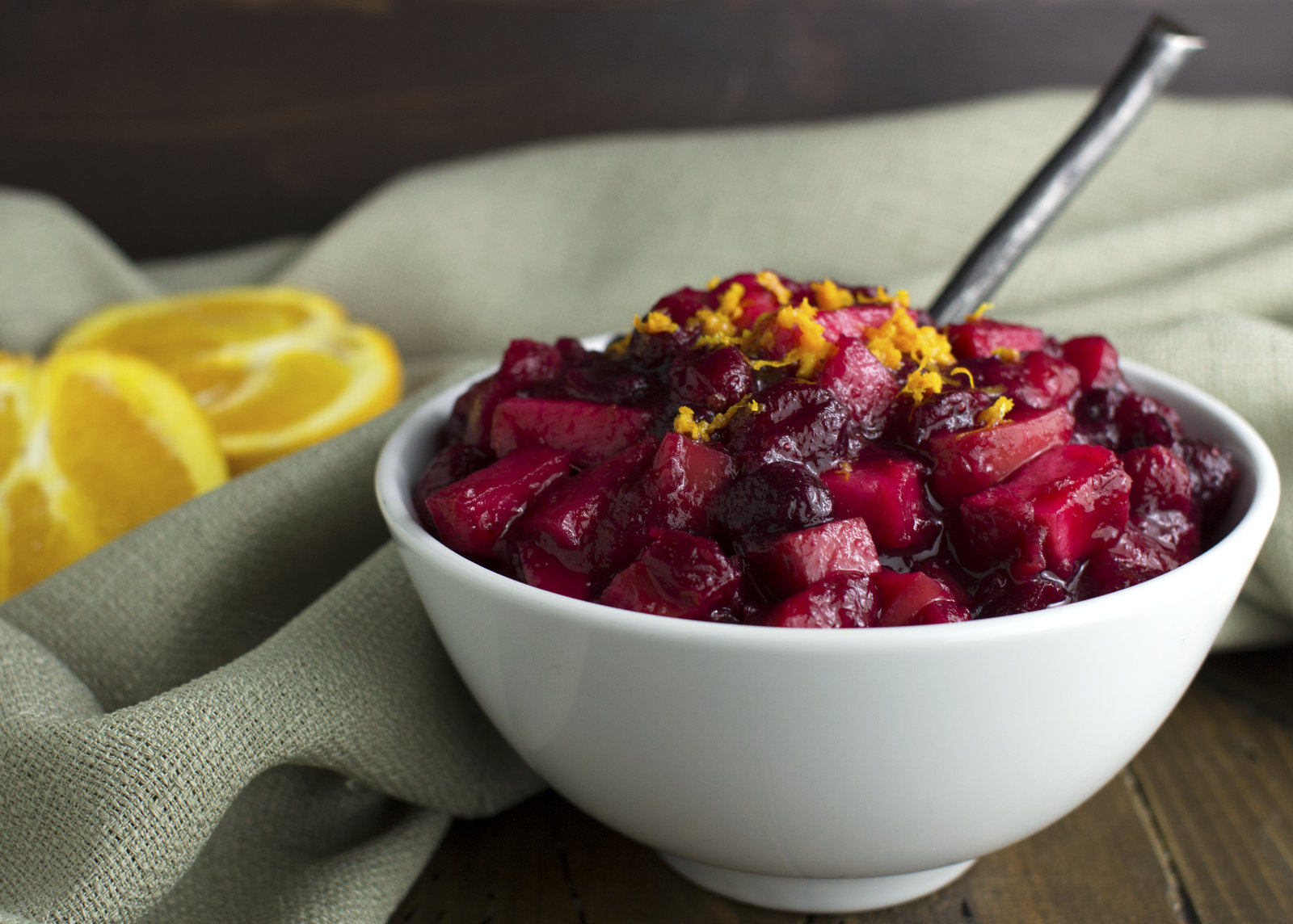 cranberry sauce served in a white bowl with some orange zest sprinkled on top