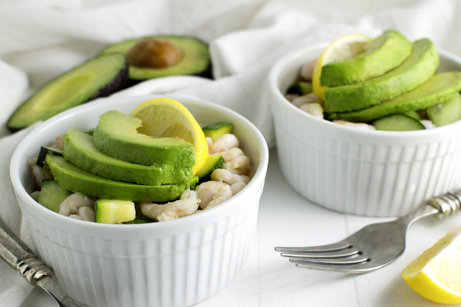 2 bowls of ceviche with sliced avocado on top