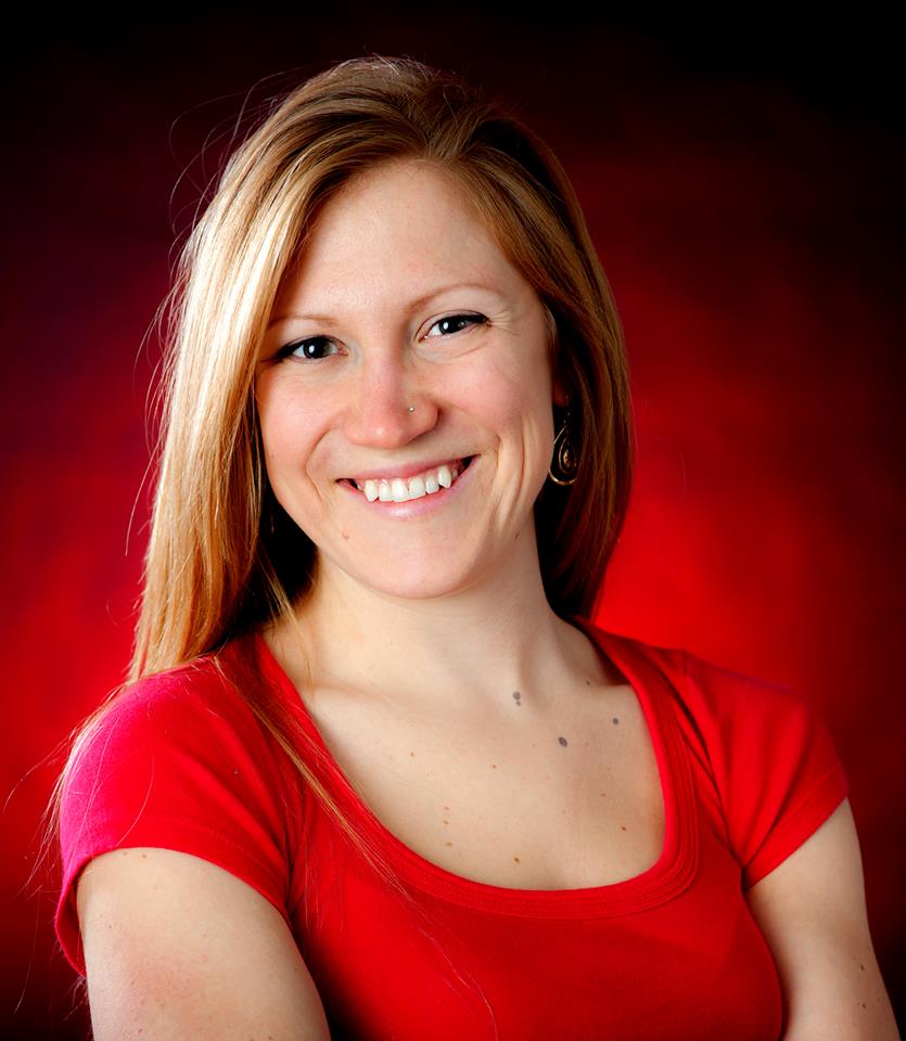 Stefani, smiling with red hair, wearing a red shirt