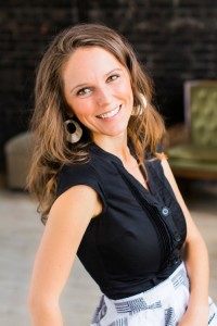 Angie smiling with long brown hair and big gold earrings