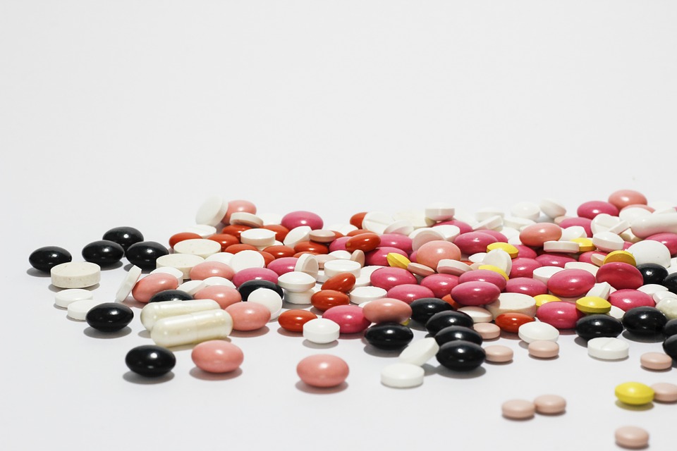 a variety of different pills scattered across a white surface