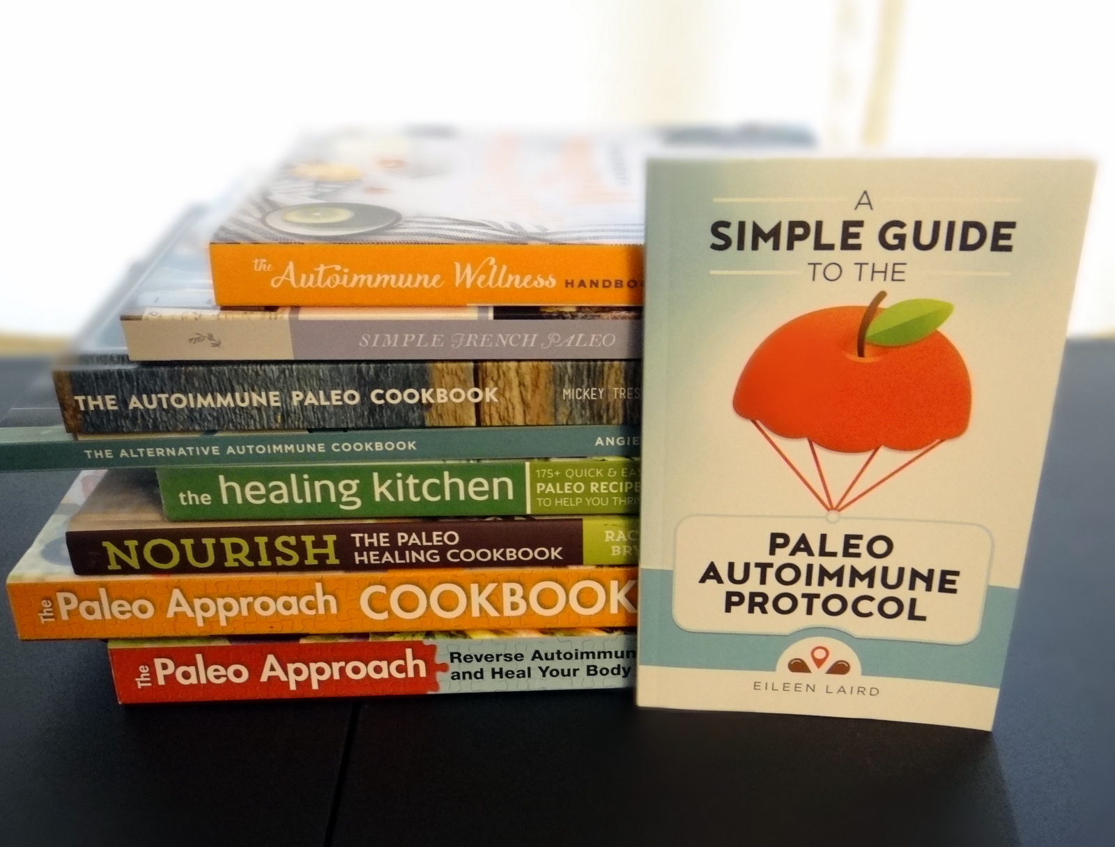 a stack of paleo AIP cookbooks