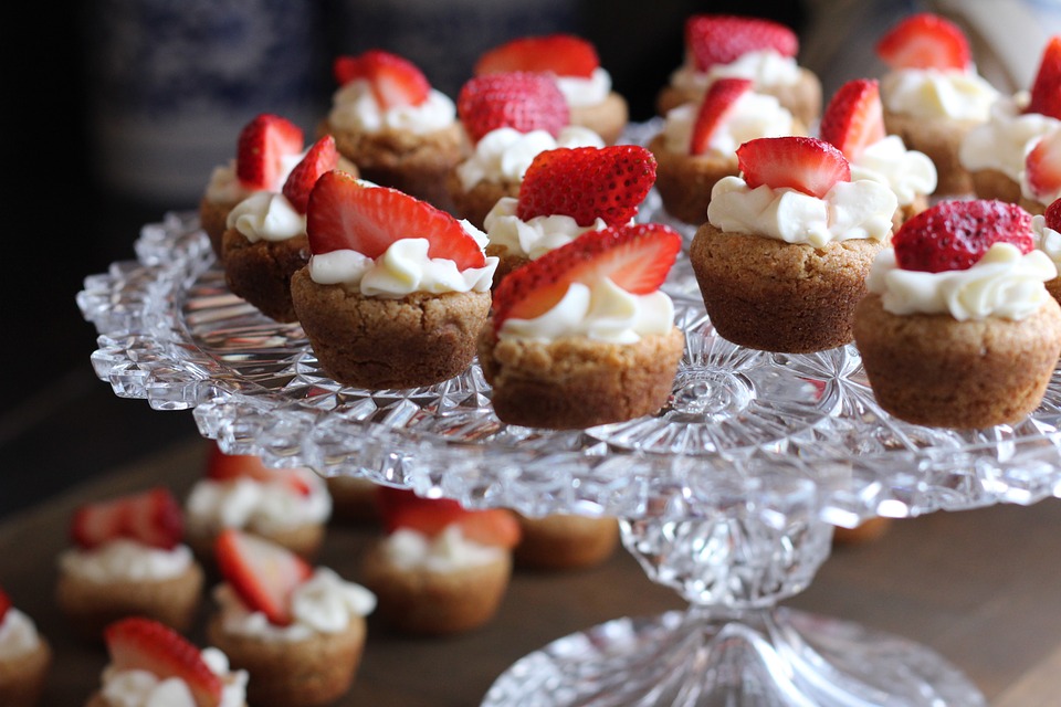 mini frosted cupcakes with strawberries on top