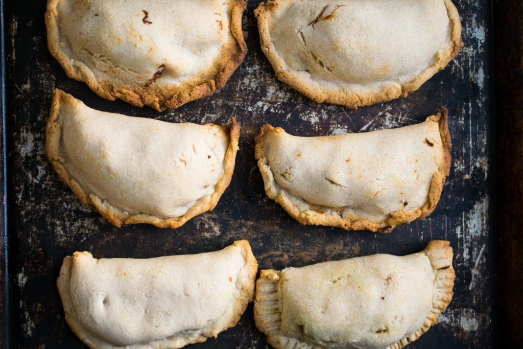 6 empanadas on a cookie sheet