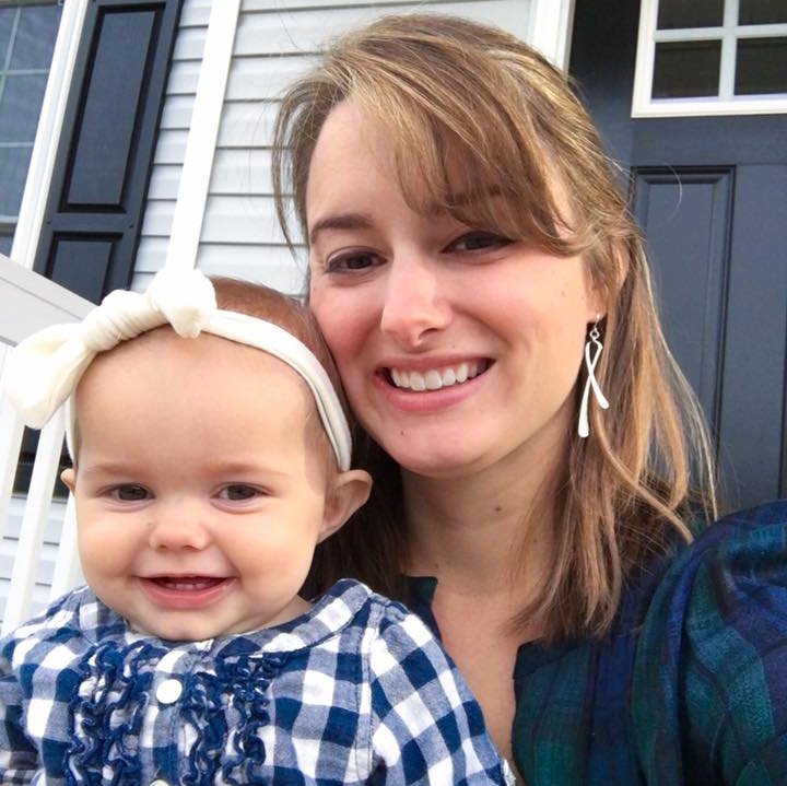 Samantha smiling and holding her baby daughter