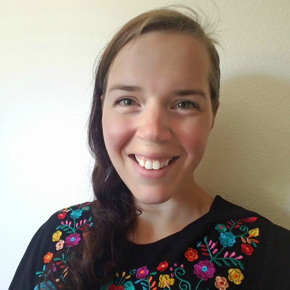 Erin smiling with long, brown, braided hair