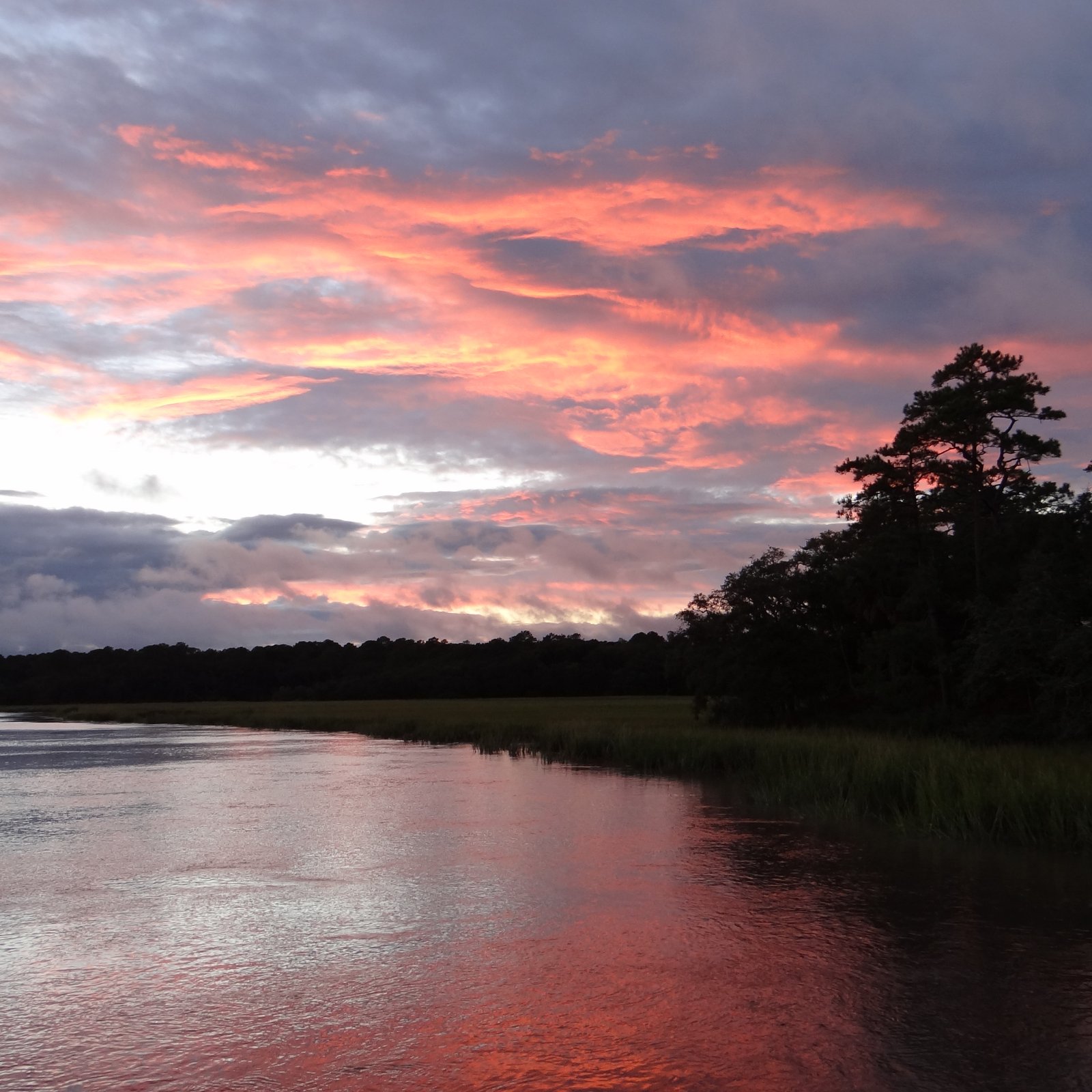 pink clouds reflected on a lake just after the sun has set