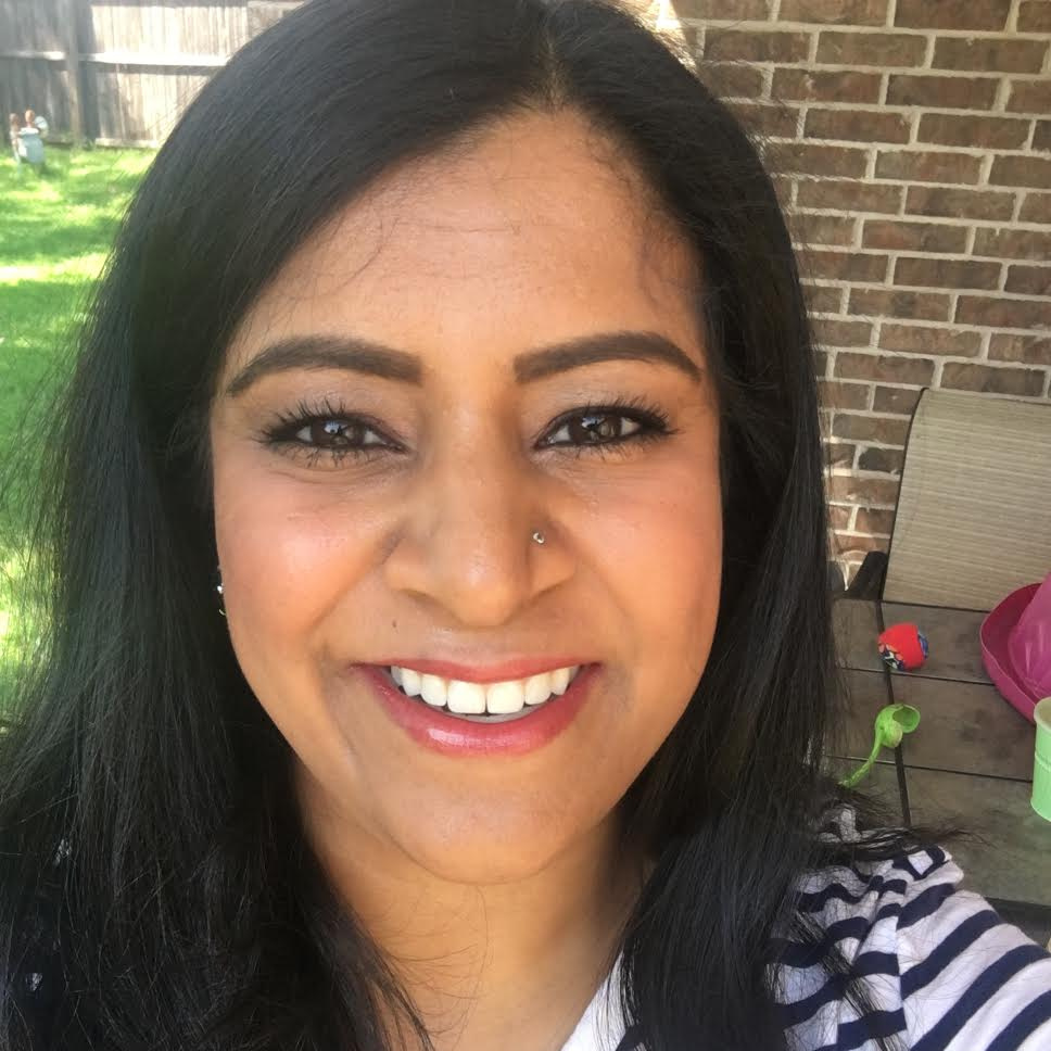 Pooja smiling, with long black hair