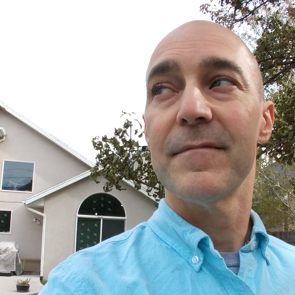 Headshot of Dan, wearing a light blue shirt and looking off into the distance