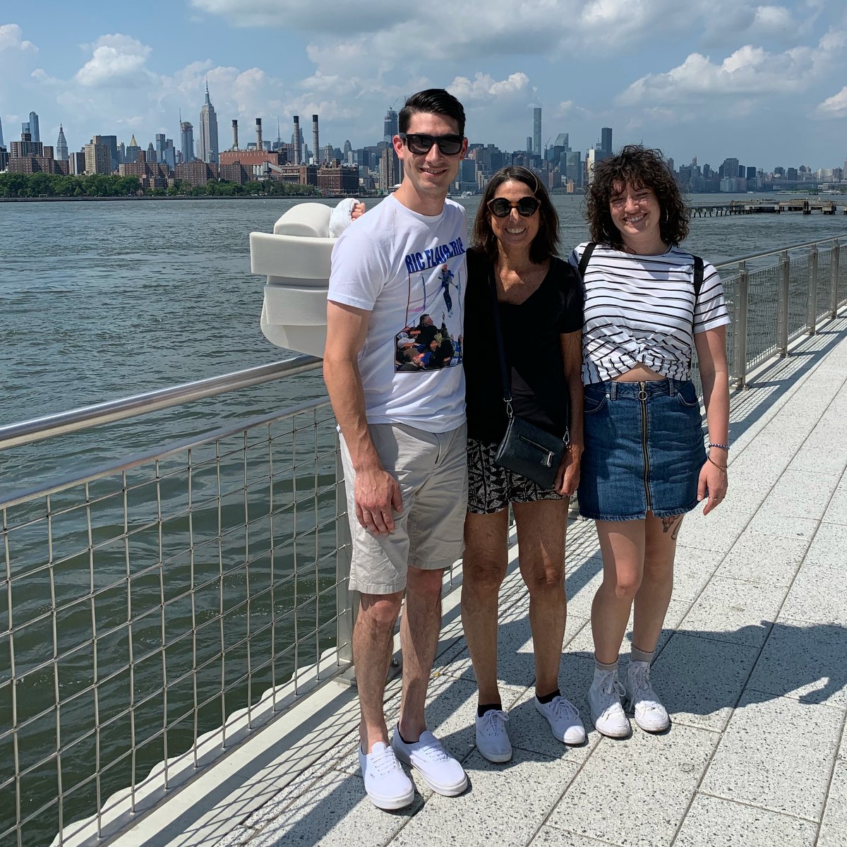 Ann on vacation with her adult children, a city skyline in the background