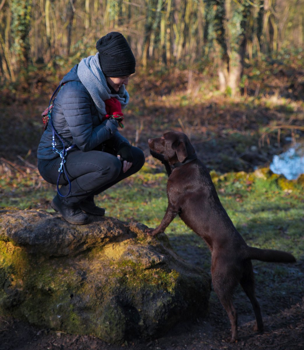 Anne-Laure and her dog looking at each other lovingly in a nature setting