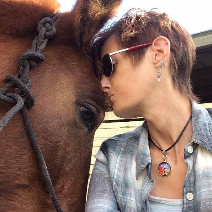 Lauri and her horse, leaning on each other, forehead to forehead