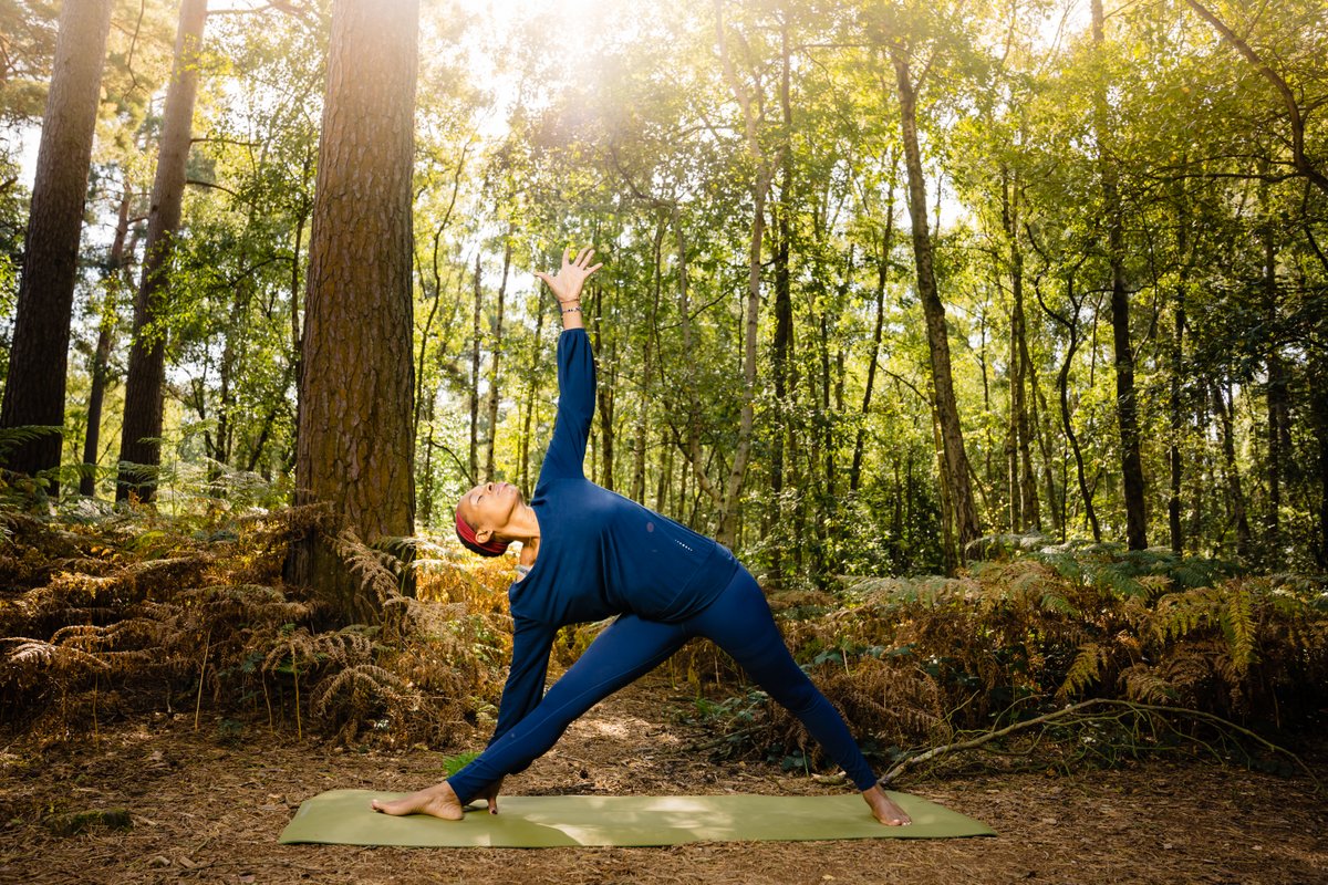 Jacqueline doing yoga - triangle pose - in a forest setting