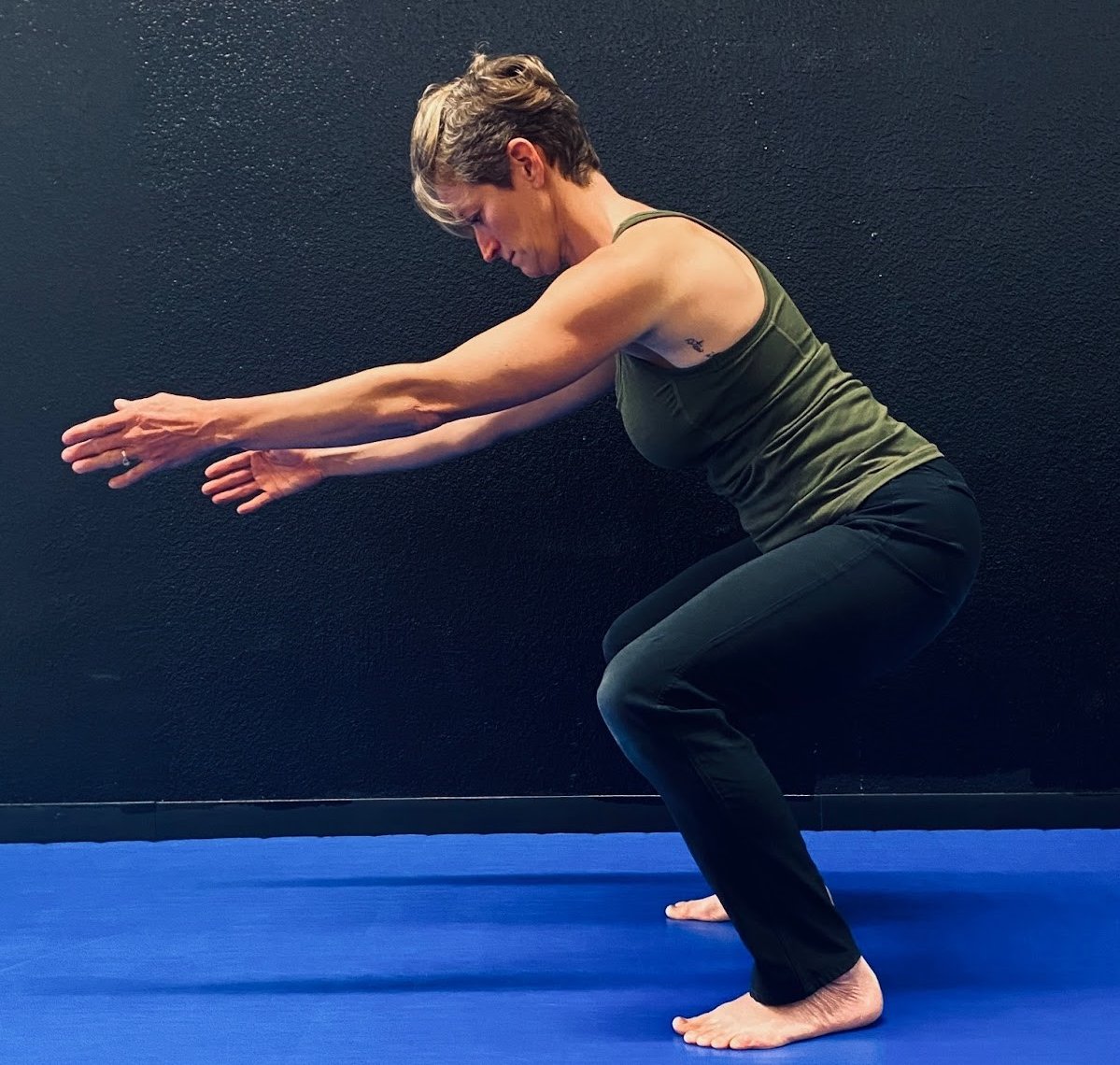Maggie demonstrating DNS exercise Primal Squat