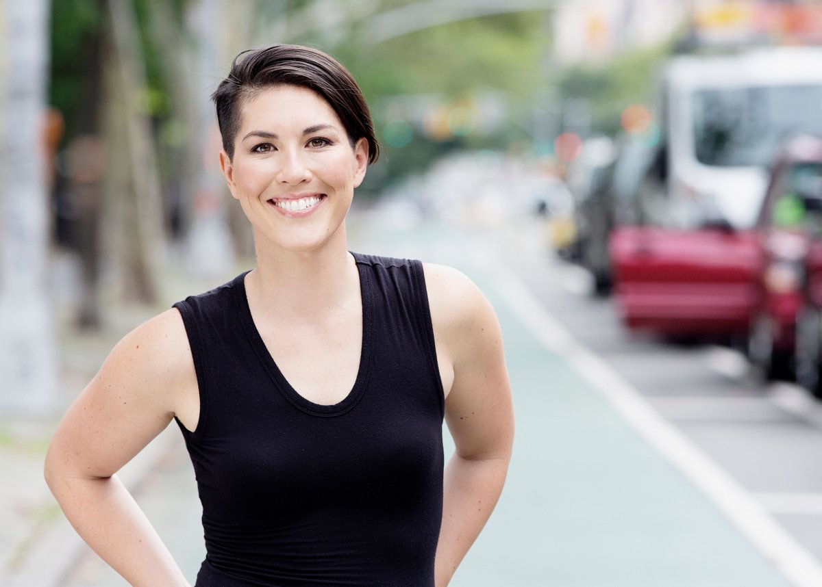 photo of emily with short brown hair, a black tank top, and a smile