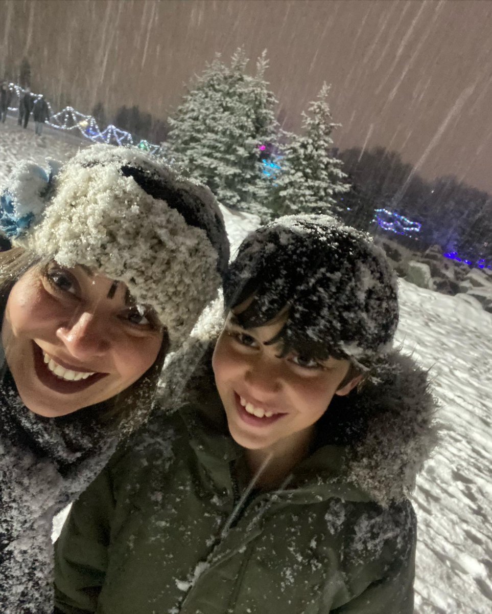 A winter photo of Jenny and her son smiling outside in a snowstorm