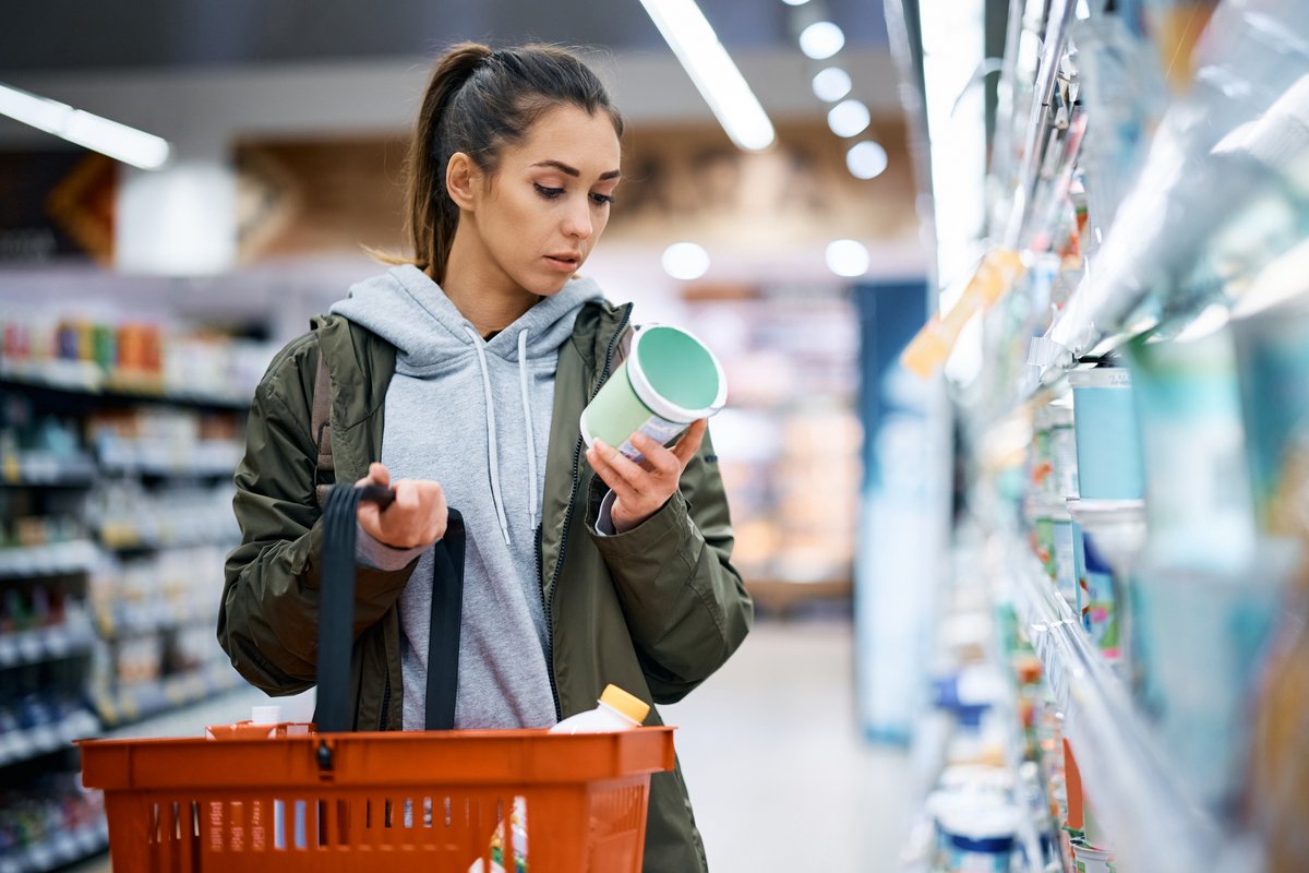 woman reading nutrition label in supermarket