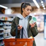 woman reading nutrition label in supermarket