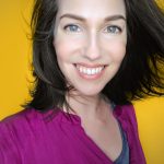 Sandy smiling with shoulder length brown hair and a bright purple shirt